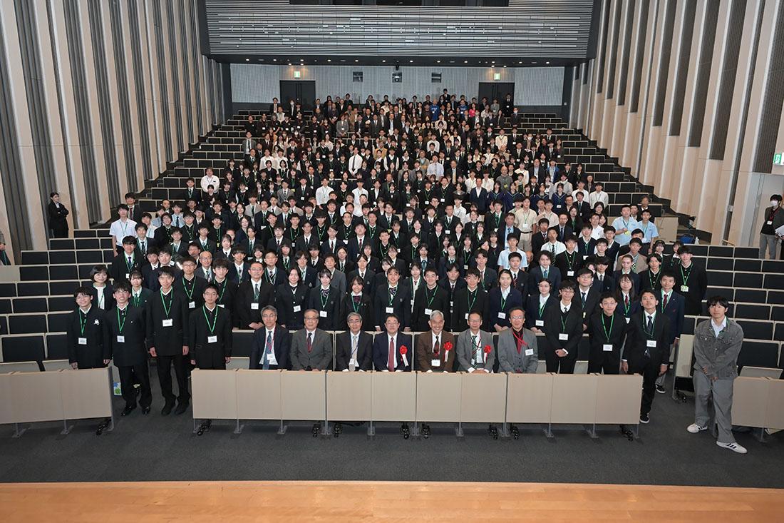 大講堂の客席に多数の参加者が並んだ集合写真